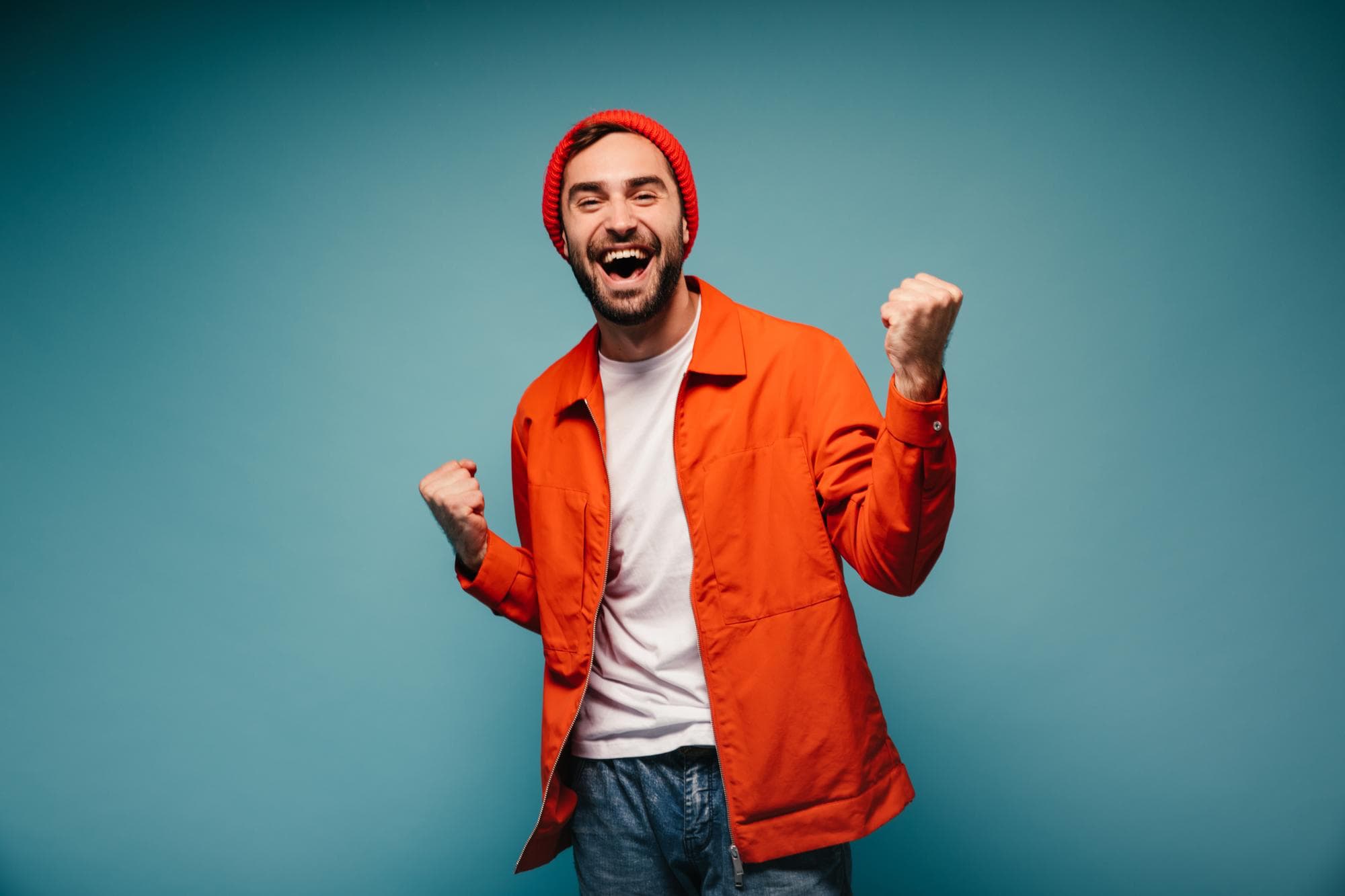 Solo young adult quietly smiling after seeing their credit score on a phone, no stadium-celebration framing
